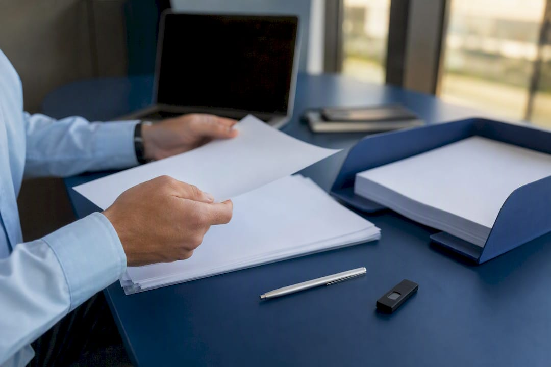 Hands organizing trademark filing documents